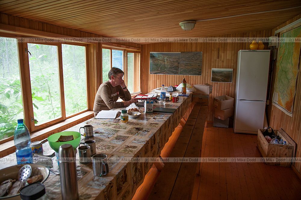 David Gowing at computer on dining table at Mukhrino fieldstation