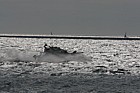 Speedboat crashing through waves against the light