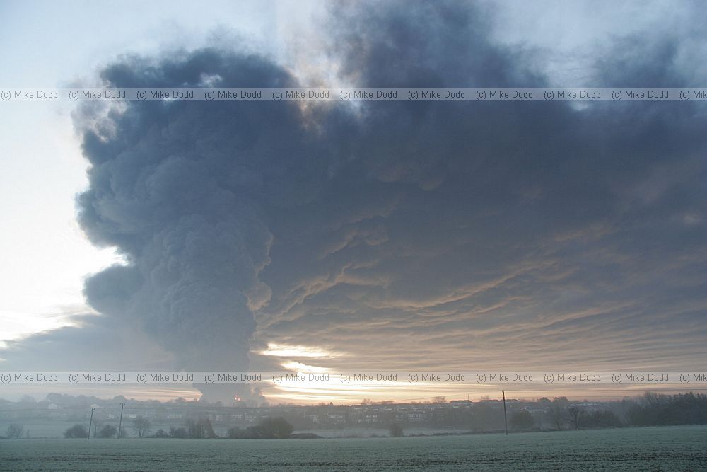 Huge fire at Buncefield oil storage depot Hemel Hempstead picture taken at dawn showing vast plume of smoke some shots with fireball too