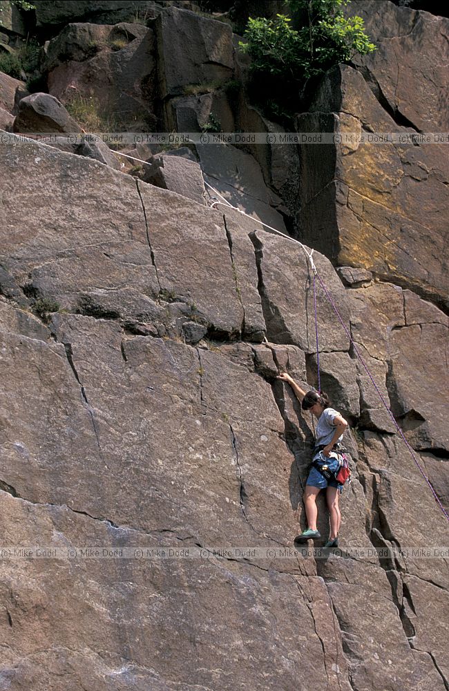 Climber on millstone grit rock Hathersage Peak District