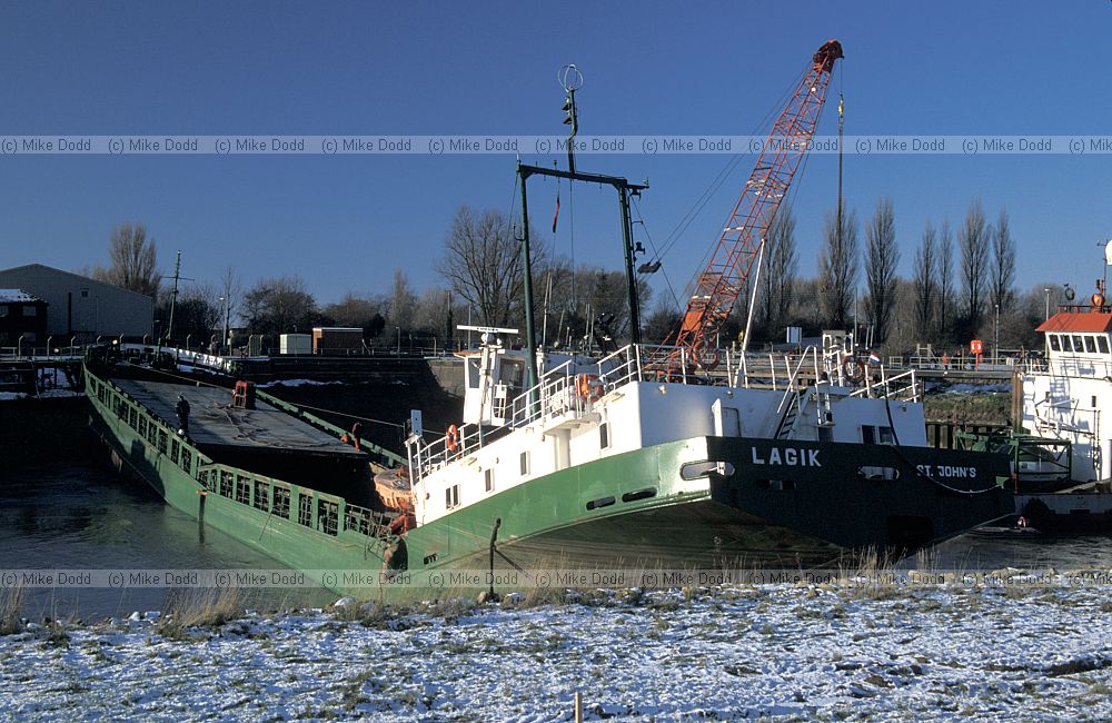 Stuck and broken ship blocking river Nene by Sutton Bridge and being cut up by salvage team