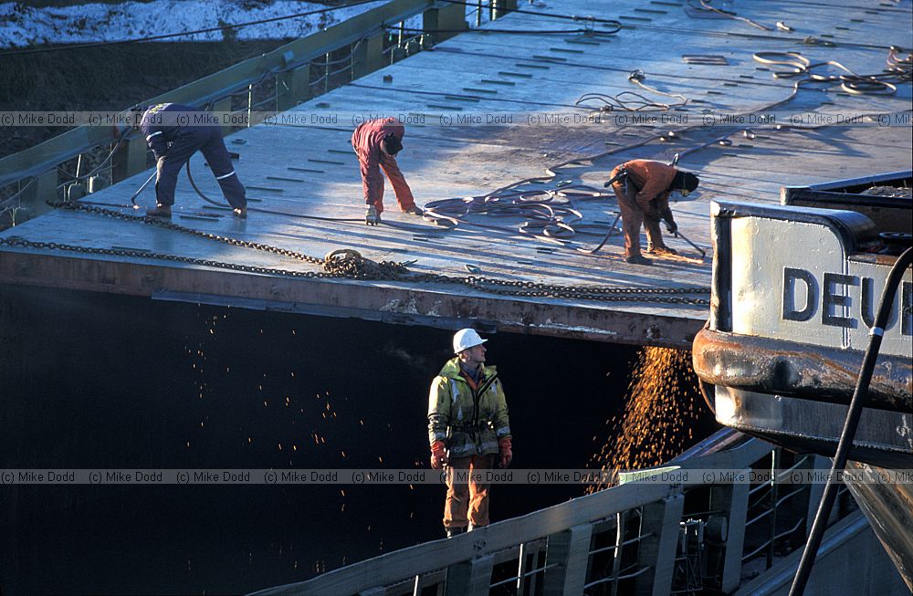 Stuck and broken ship blocking river Nene by Sutton Bridge and being cut up by salvage team