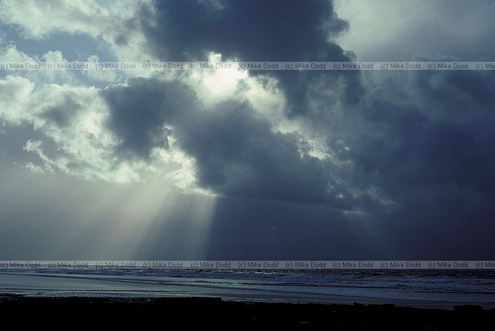 Storm clouds over the sea with sunbeams