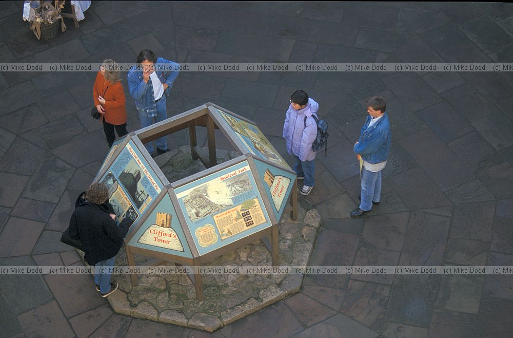 People looking at information board York castle