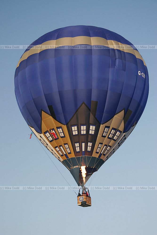 Hot air balloon taking off people visible in basket blue sky at Northampton balloon festival dawn