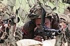 British army machine gunners under camouflage netting