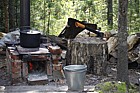 Outdoor cooking area with axe and cooking pot on fire