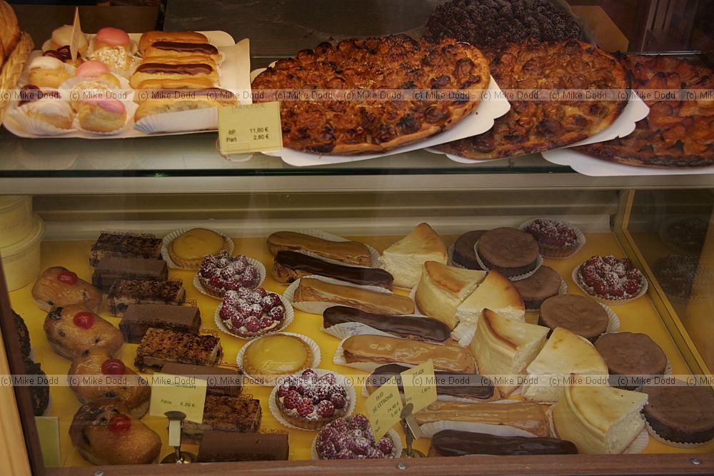 Cakes in window of shop patisserie Rue Mouffetard Food Market Paris