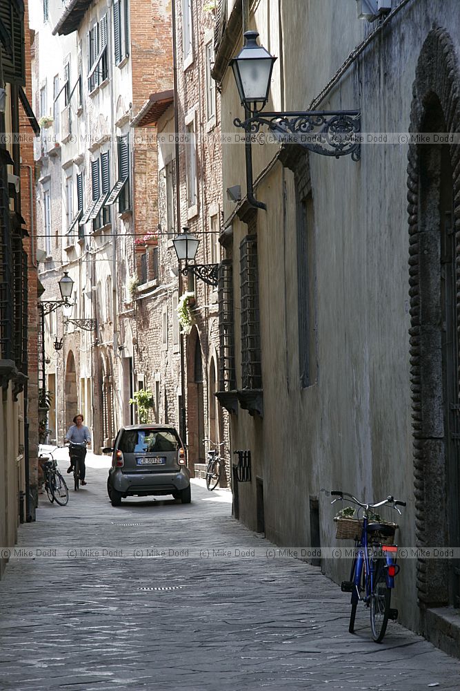 Narrow street with car and bikes Lucca