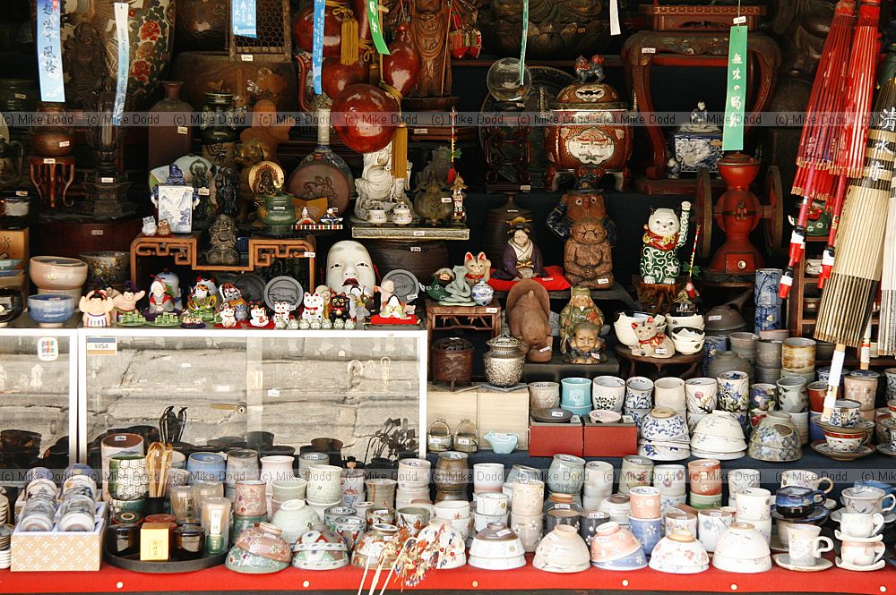 Touristy shop window with rice bowls tea cups and cats