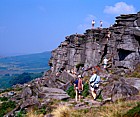 Climbers on millstone grit rocks Stannage edge Peak District