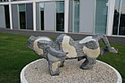 Bounding bull sculpture by Dominic Benhura in springstone inset with crushed dolomite at Open University Walton Hall Milton Keynes