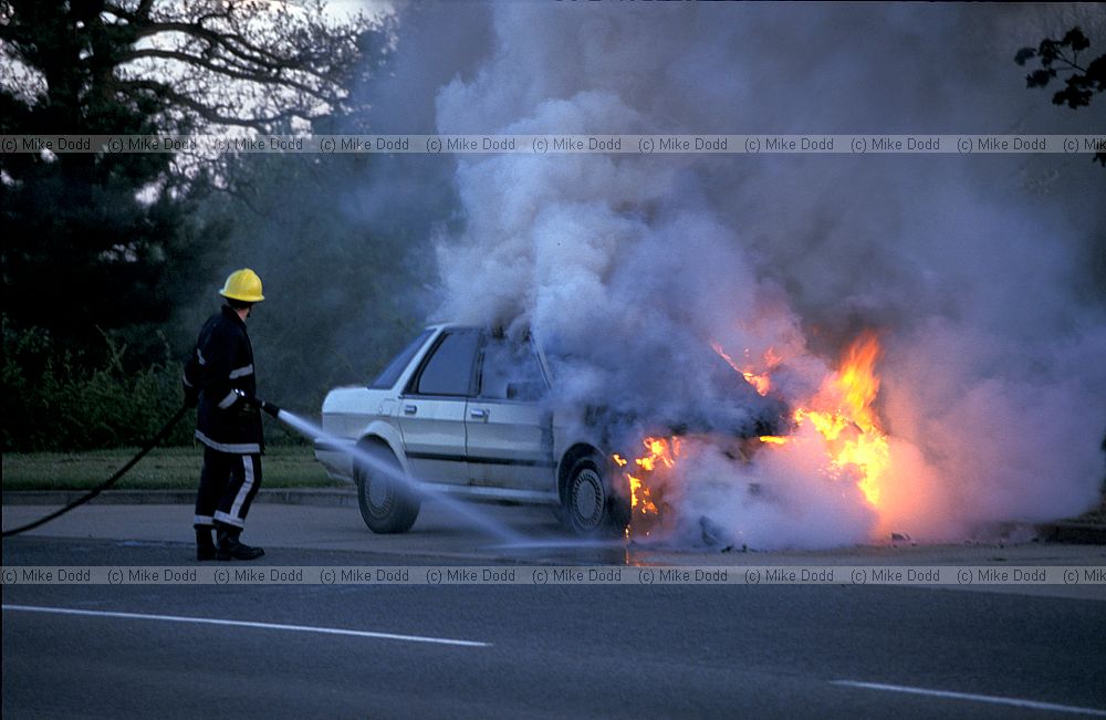 Fireman, burning car at Willen, flames and smoke, Milton Keynes