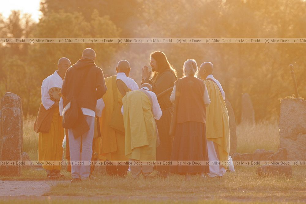 Nick the priest greets Buddhist monks moments after sunrise summer solstice ceremonies at Willen stone circle Milton Keynes
