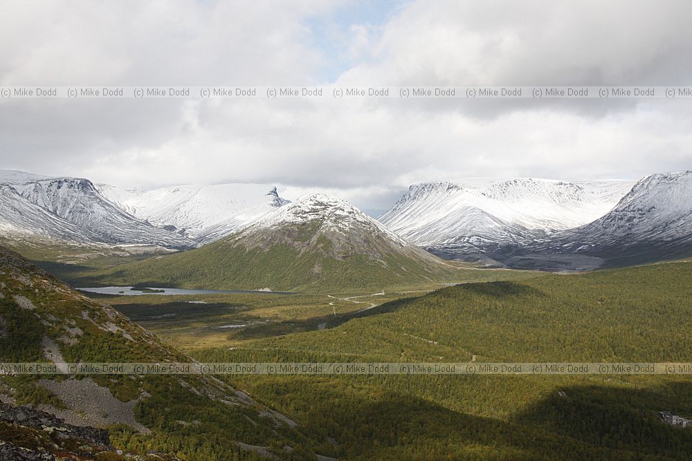 Khibini mountains with green leaves on the birch trees and snow on the higher slopes