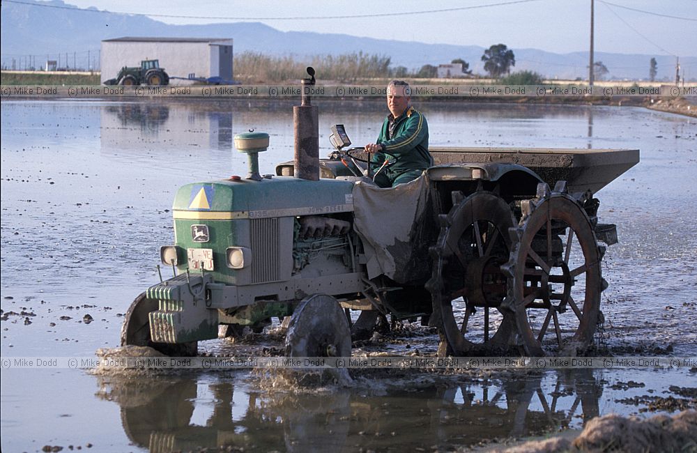 Tractor planting rice in flooded field Ebro delta