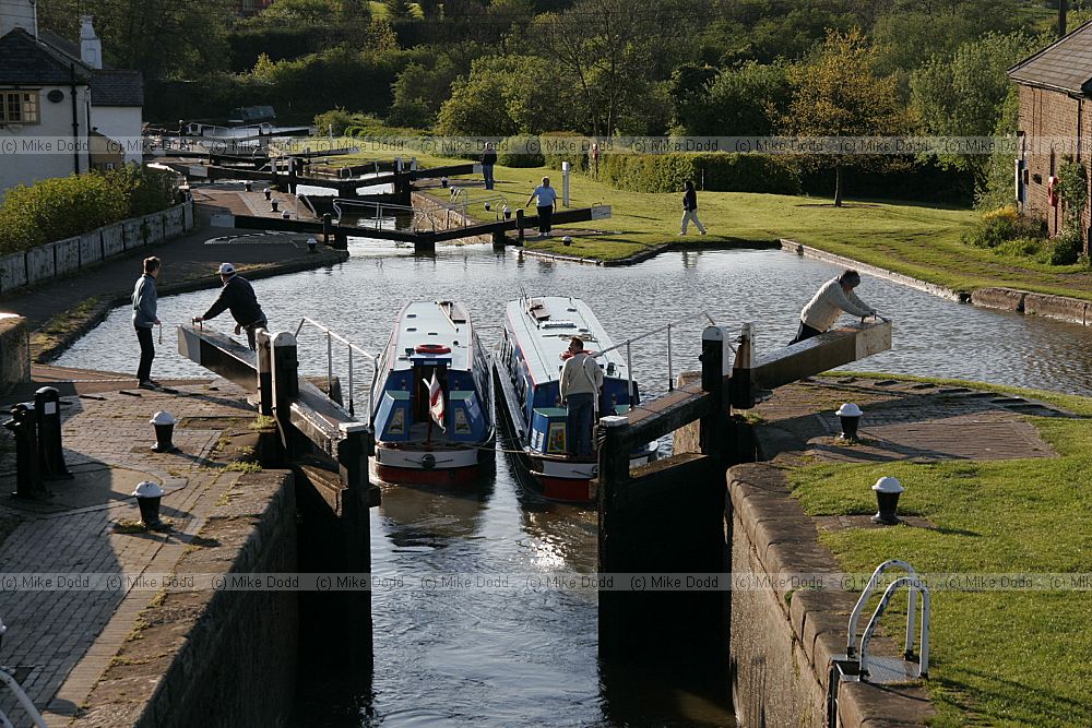 canalboats going through locks and water overflowing locks