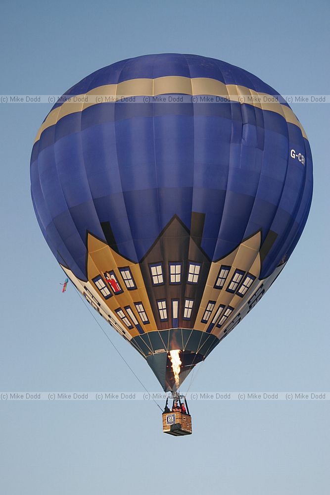 Hot air balloon taking off people visible in basket blue sky at Northampton balloon festival dawn